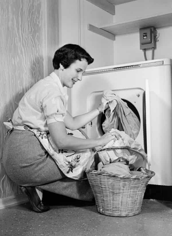 A woman empties a washing machine