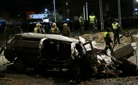A destroyed car is pictured near the site where a military plane crashed in el Alto.