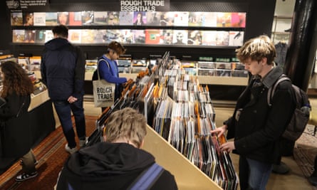 young people look through shelves stacked with vinyl records