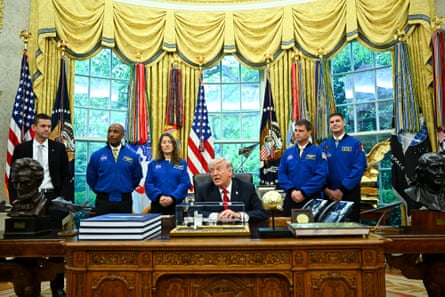 a group of people stand behind a man seated at a desk