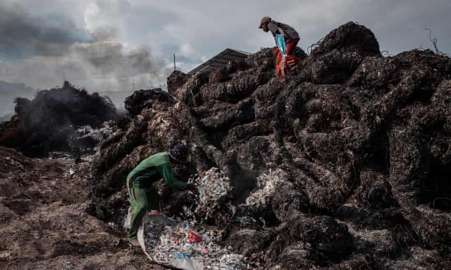 Workers prepare to burn plastic at a dump for imported waste in Mojokerto in East Java, Indonesia