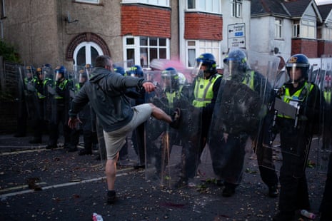 A man is seen kicking riot police.
