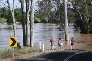 People are seen watching the Mary River flood near Tiaro, about 200km north of Brisbane, on Sunday.