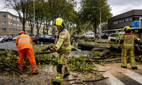 THE HAGUE - Firefighters clear a fallen tree at the Leyenburg shopping center. A woman became trapped and had to be freed by the fire brigade.
