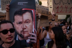A man holds the poster with the images of President Volodymyr Zelenskyy and former pro-Russian Ukrainian president Viktor Yanukovich, during a protest against a new bill curtailing anti-corruption agencies in Kyiv