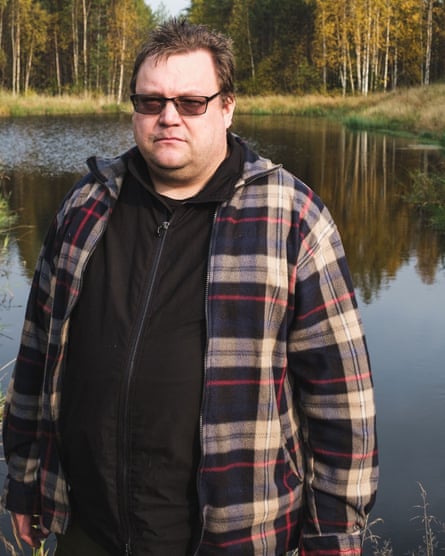Tero Mustonen standing by a stretch of water with trees in the background.