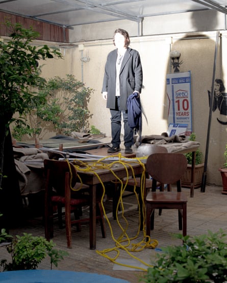 A woman stands symbolically on a table in a café in Tehran