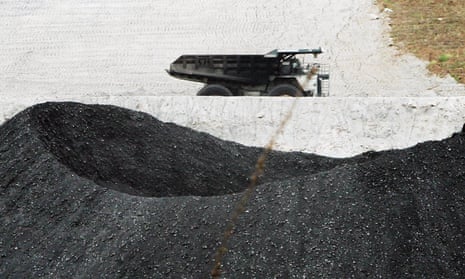 A coal truck passes coal at a BHP mine