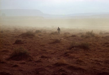 A Native American walks through the yellow landscape of a Nevada dust storm. USA, 1970