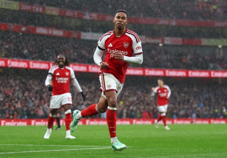 Arsenal's Gabriel Magalhaes jogs celebrating a goal, with teammates in the background