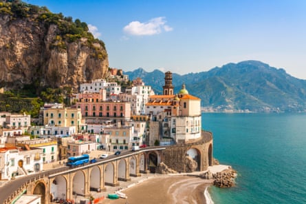 A small town on the Amalfi Coast overlooking the ocean with mountains in the background.