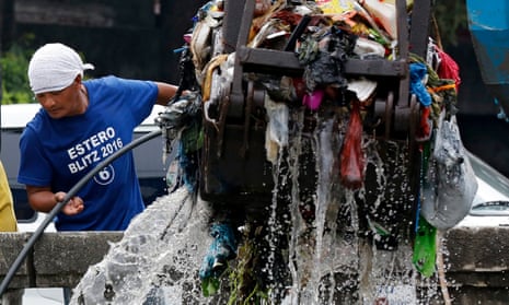 A government worker clears rubbish from a a river in Manila, the Philippines.