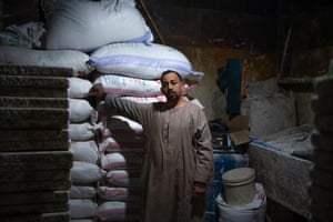 a baker in a djellaba stands by sacks of flour