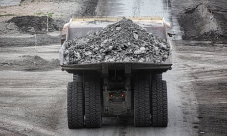 A truck carrying a load drives through a mining site