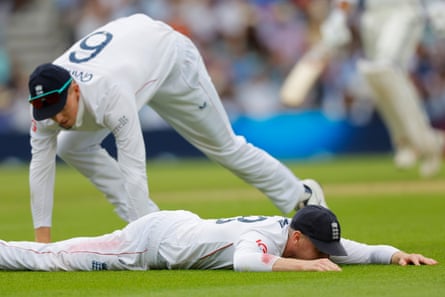 Harry Brook of England lies on the ground after dropping Karun Nair of India.