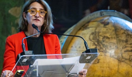 Teresa Ribera speaking into a mic next to a giant globe.