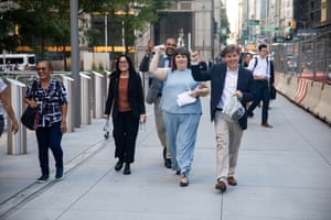 people raise their fists as they walk on the sidewalk