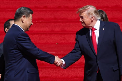 Donald Trump and Xi Jinping shake hands, facing each other against a red backdrop