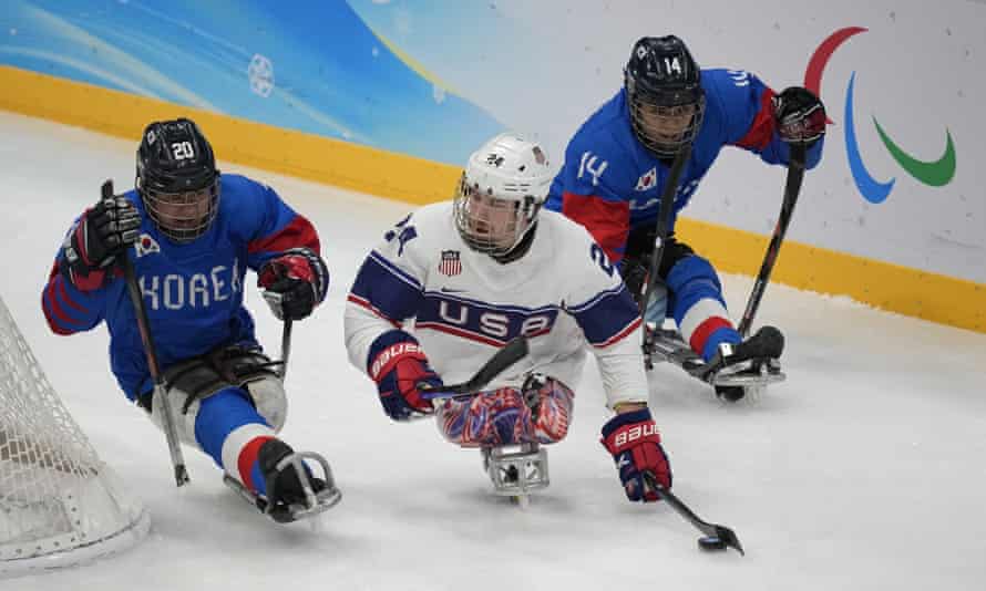 Joshua Misiewics of the United States, center, battles for the puck against South Korea’s Jang Dong-shin and Jung Seung-hwan during their para ice hockey match.