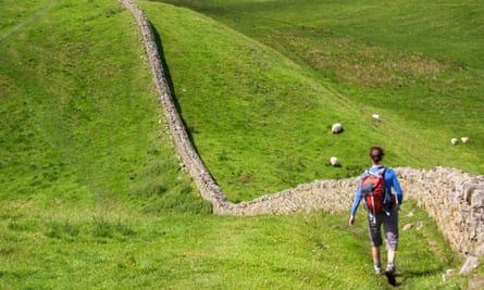 Hiker walking alongside Hadrians Wall