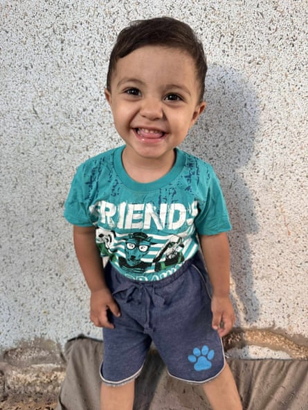 A smiling toddler boy wearing shorts and a T-shirt
