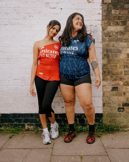 Two smiling women in upcycled Arsenal tops - one in red, the other dark blue