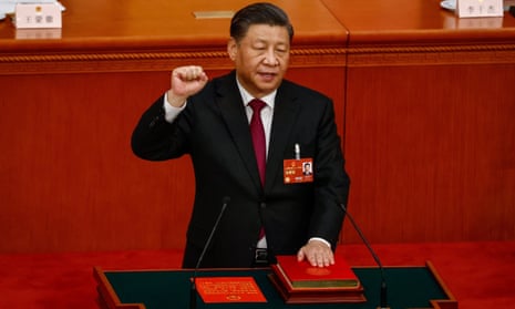 President Xi Jinping holds up his fist and places his hand on China’s constitution in the Great Hall of the People in Beijing