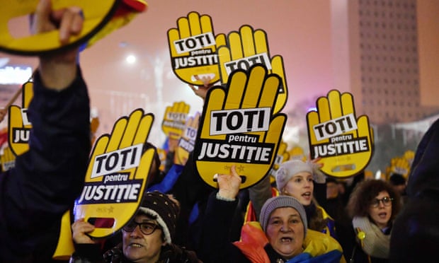 People hold placards reading: ‘All for justice’ during a protest against the Romanian government and corruption in Bucharest.