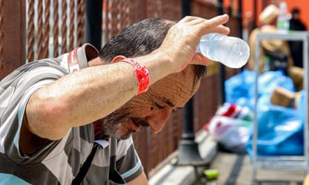 A man pours a bottle of water over his head