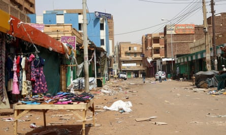 People walk down a mostly empty street in Omdurman, Sudan