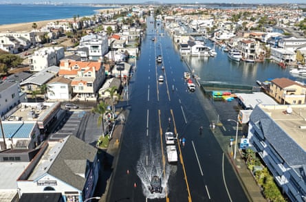 Aerial view of a vehicle driving through flooded Pacific Coast Highway in Huntington Beach