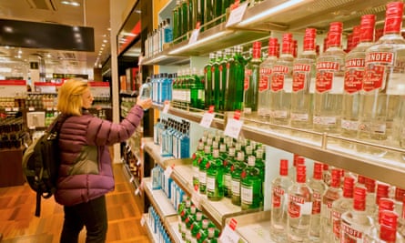 Woman traveller shopping for duty free alcohol in an airport duty free shop