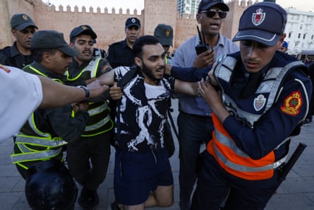 At least four police officers detain a man.