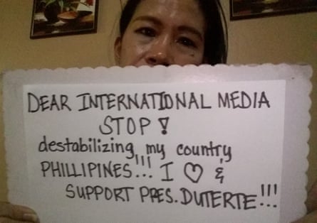 Filipino woman holding a sign to international media asking them to stop ‘destabilizing my country Philippines’