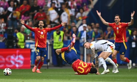 Spain midfielder Pedri hits the ground after a challenge from Germany’s Toni Kroos.