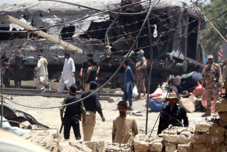 Security officials and rescuers inspect wrecked carriages at the scene of a deadly train blast in Quetta, Pakistan.
