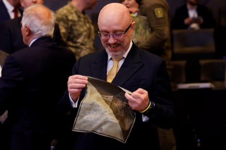 Ukraine's defence minister Oleksii Reznikov holds a handkerchief with a fighter jet image as he attends the Nato defence ministers' meeting at the Alliance's headquarters in Brussels.