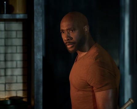 Morris Chestnut carrying a baseball bat in dim light