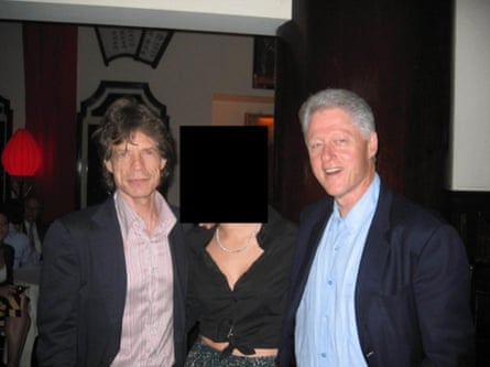 Jagger and Clinton pose for a photo with a woman whose face has been redacted