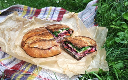 A huge sandwich in an entire loaf of bread, with many colourful layers
