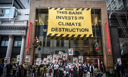 Climate activists protesters outside Wells Fargo in San Francisco, with big sign reading this bank invests in climate destruction
