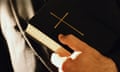 Anonymous generic Catholic Priest holding bible.