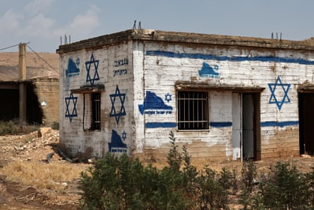 A graffito reading ‘Greater Israel’ and several Stars of David are painted on Palestinian property