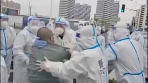 Video footage shared on social media showed residents scuffling with hazmat-suited police who were forcing them to surrender their homes for coronavirus quarantine facilities
