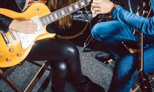 Guitar music teacher helping his student