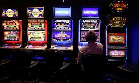 A person gambles on a poker machine at a pub