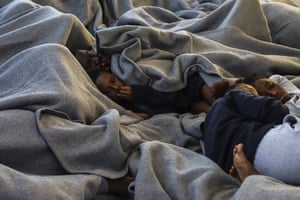 Migrants rest on the deck of the rescue ship Sea-Watch in the Maltese search-and-rescue zone