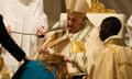 Pope Francis baptises a faithful as he presides over the Easter vigil celebration in St. Peter's Basilica at the Vatican