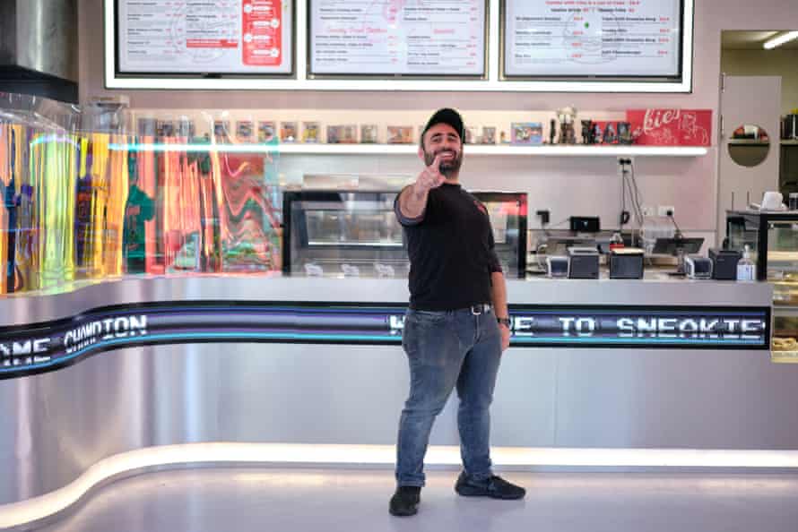 Proprietarul furtunilor, Baris Kopuz, stând în restaurantul său. El zâmbește și arată spre cameră