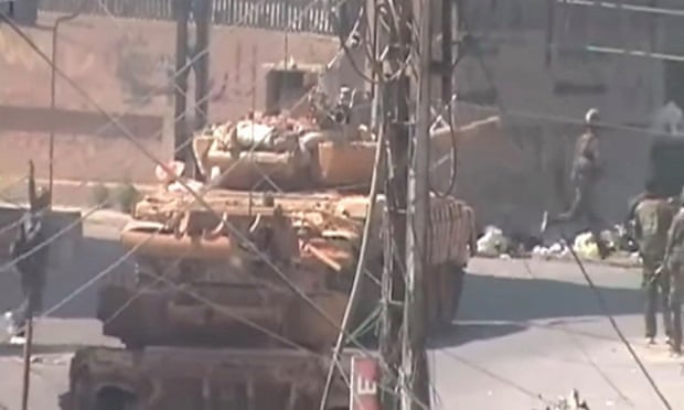A tank advances into Daraya during the assault on the town by Syrian government and allied forces in August 2012.